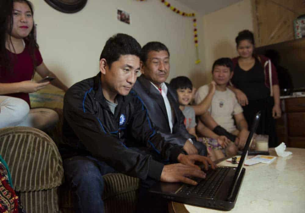 nhóm gia đình tụ tập quanh máy tính xách tay ở nhà