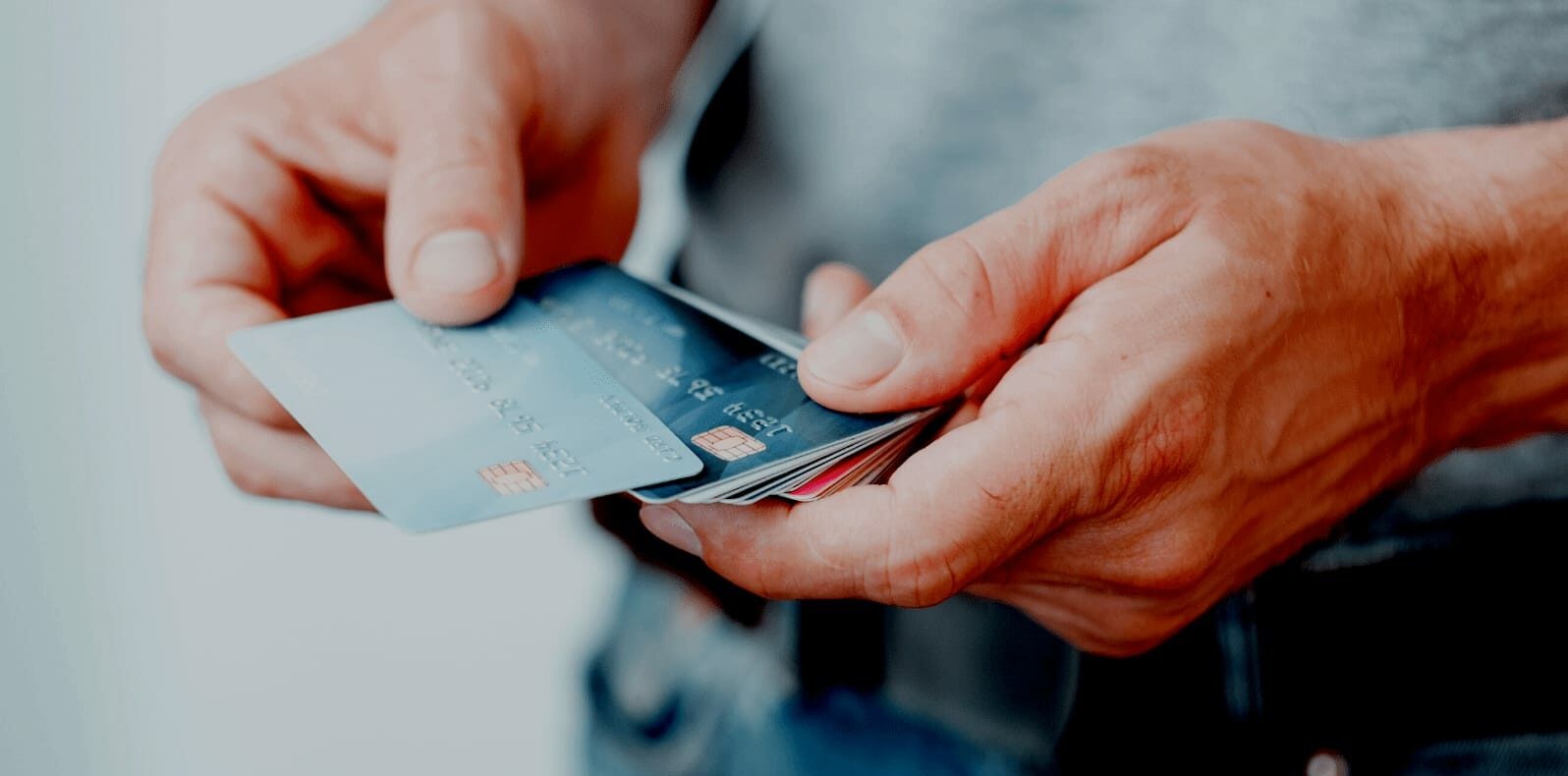 Cận cảnh bàn tay của một người đang cầm nhiều thẻ tín dụng