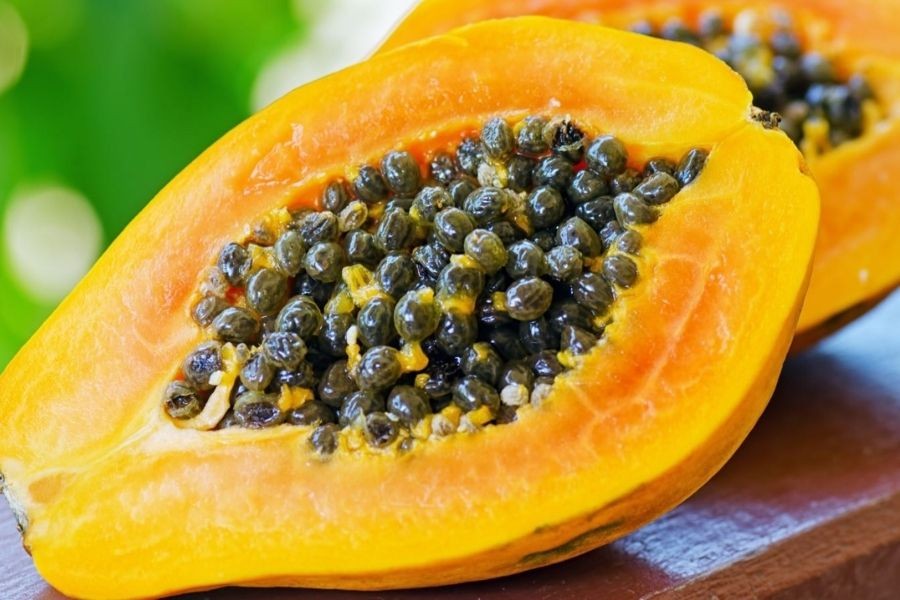 Trái đu đủ được bổ đôi, để lộ phần thịt quả màu cam và nhiều hạt bên trong, minh chứng cho sự đầy đặn.