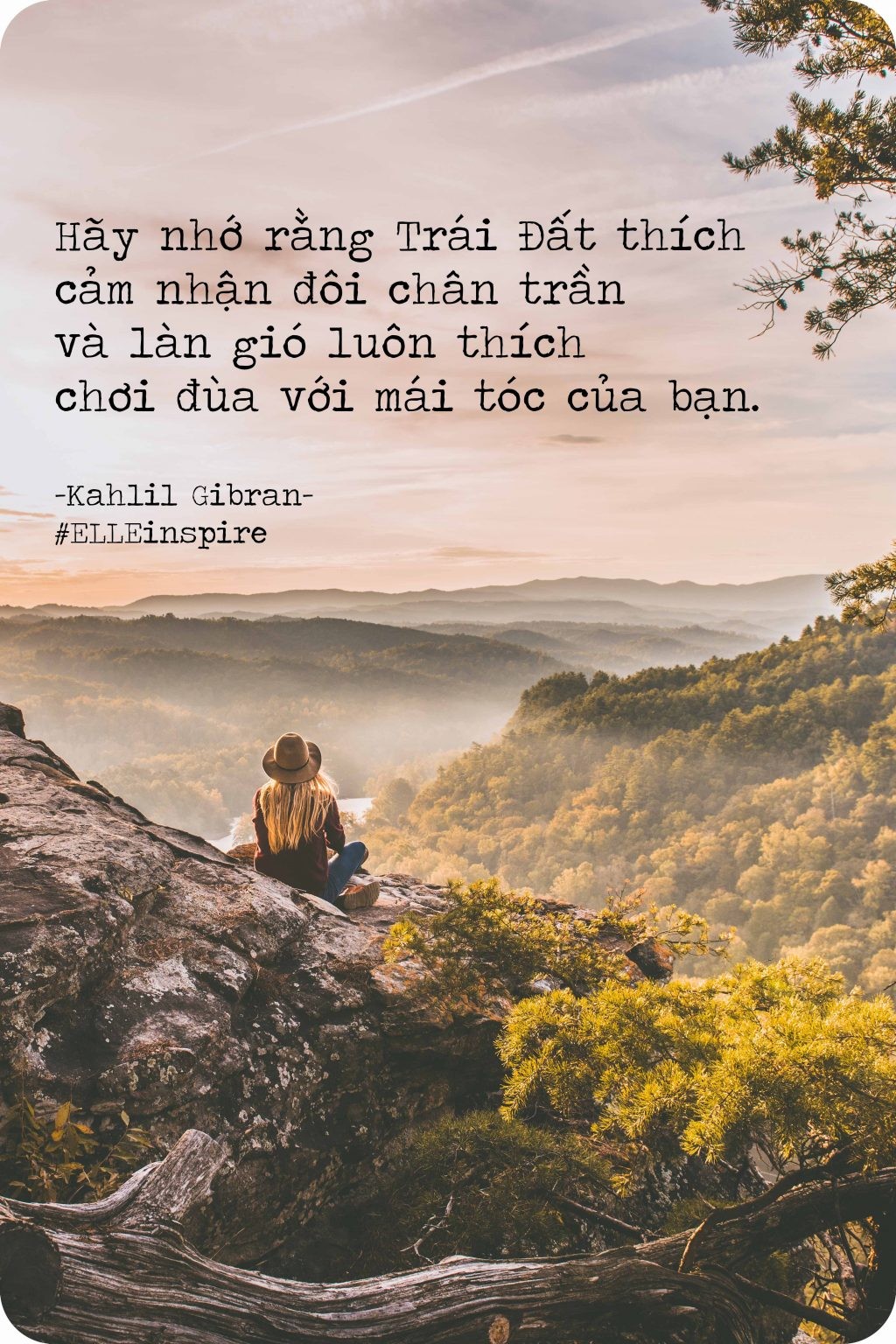 Một phụ nữ đang đi bộ trên bãi biển với mái tóc bay trong gió