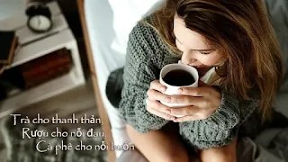Một tách cà phê đen nóng đặt trên bàn gỗ, bên cạnh là cuốn sách